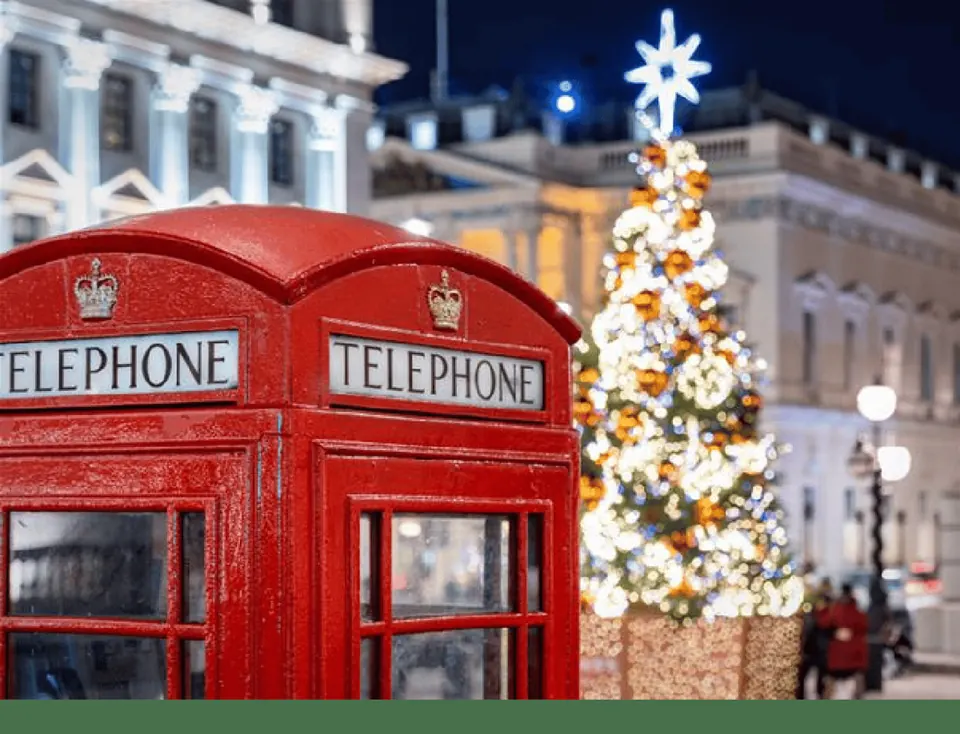 Red London telephone boxes beside a glowing Christmas tree