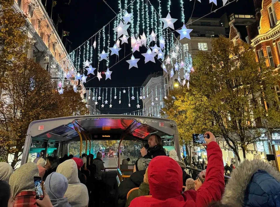 Christmas stars and cascading lights above an open-top sightseeing bus